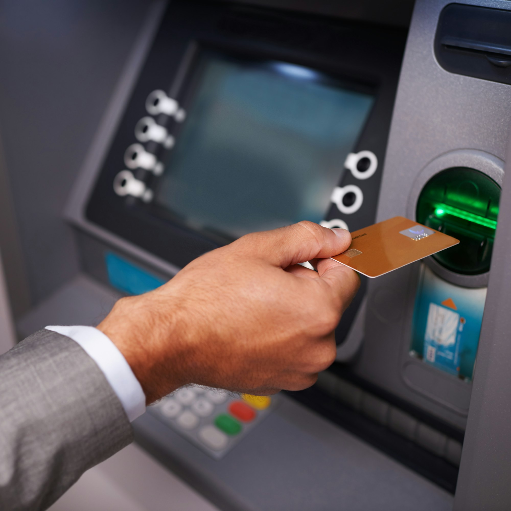 Need some cash. Cropped shot of a businessman inserting his bank card at an ATM.