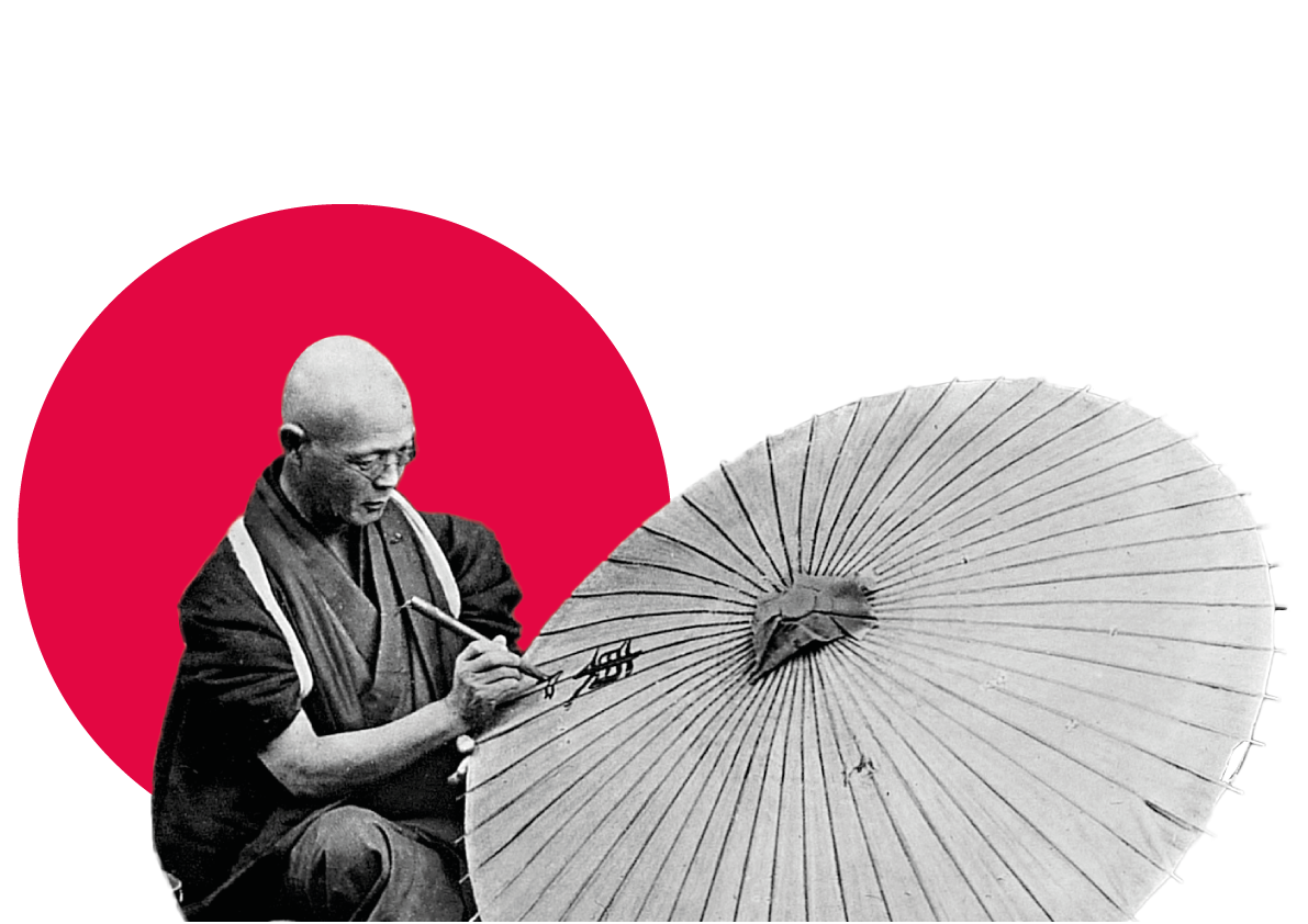Artist painting Japanese umbrella against red circle backdrop.