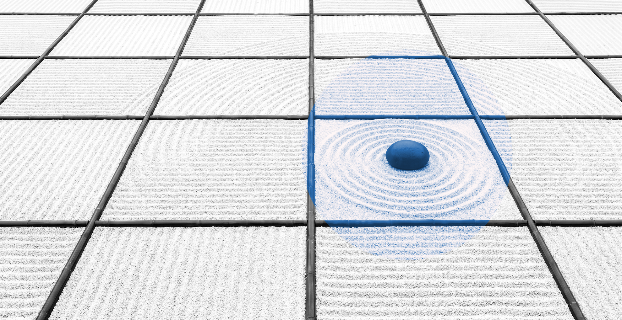 Black-and-white raked-gravel garden divided by bamboo strips into identical plots, with one dark stone and its ripple rings inside a blue circle.