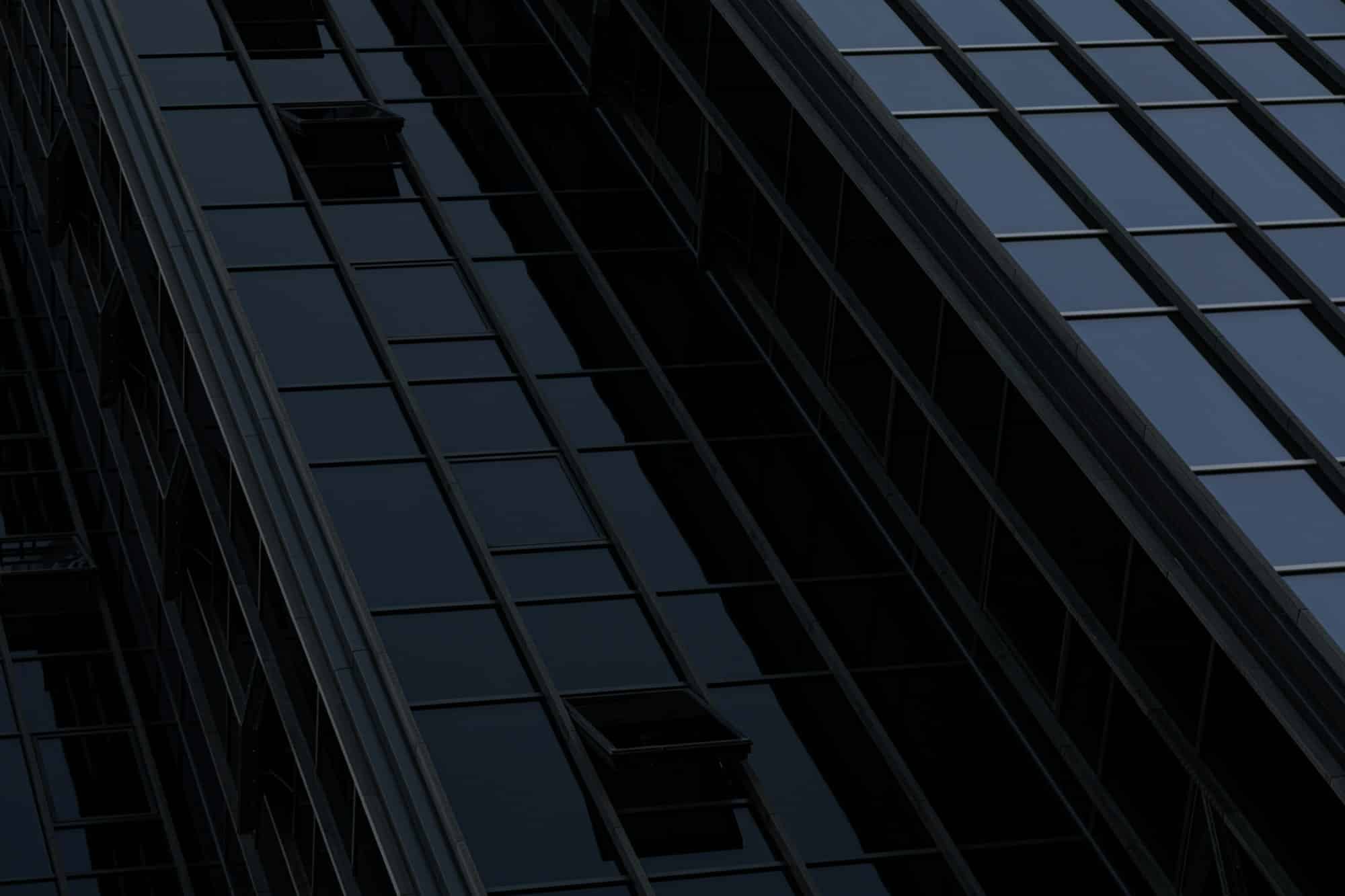 Black wall of building with opened windows