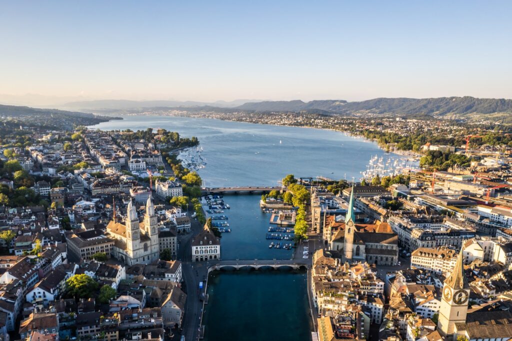 Aerial drone shot flying above Lake Zurich, Switzerland in sunny day.