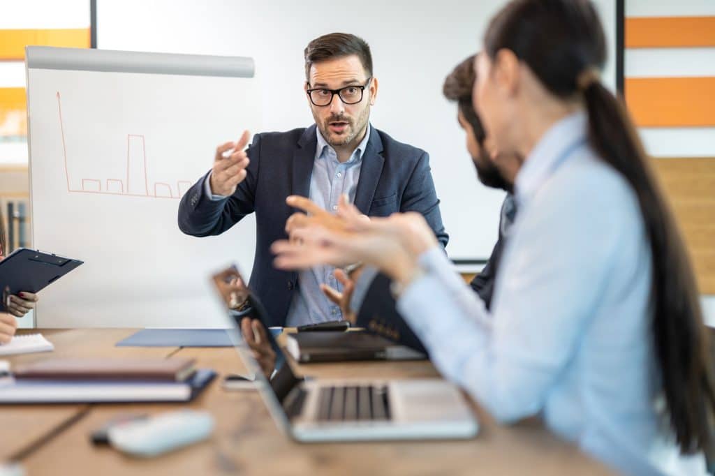 Stressed boss and executive team searching for problem solution at meeting at office