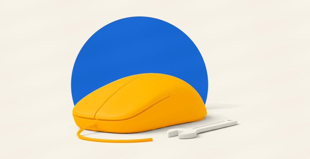 A large amber computer mouse lying in front of a cobalt disc, with a small cream wrench beside it