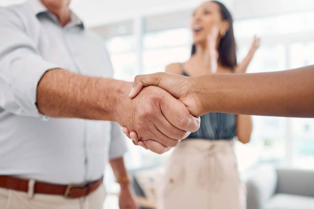 Handshake, partnership and b2b with a business man shaking hands with a colleague in the office for