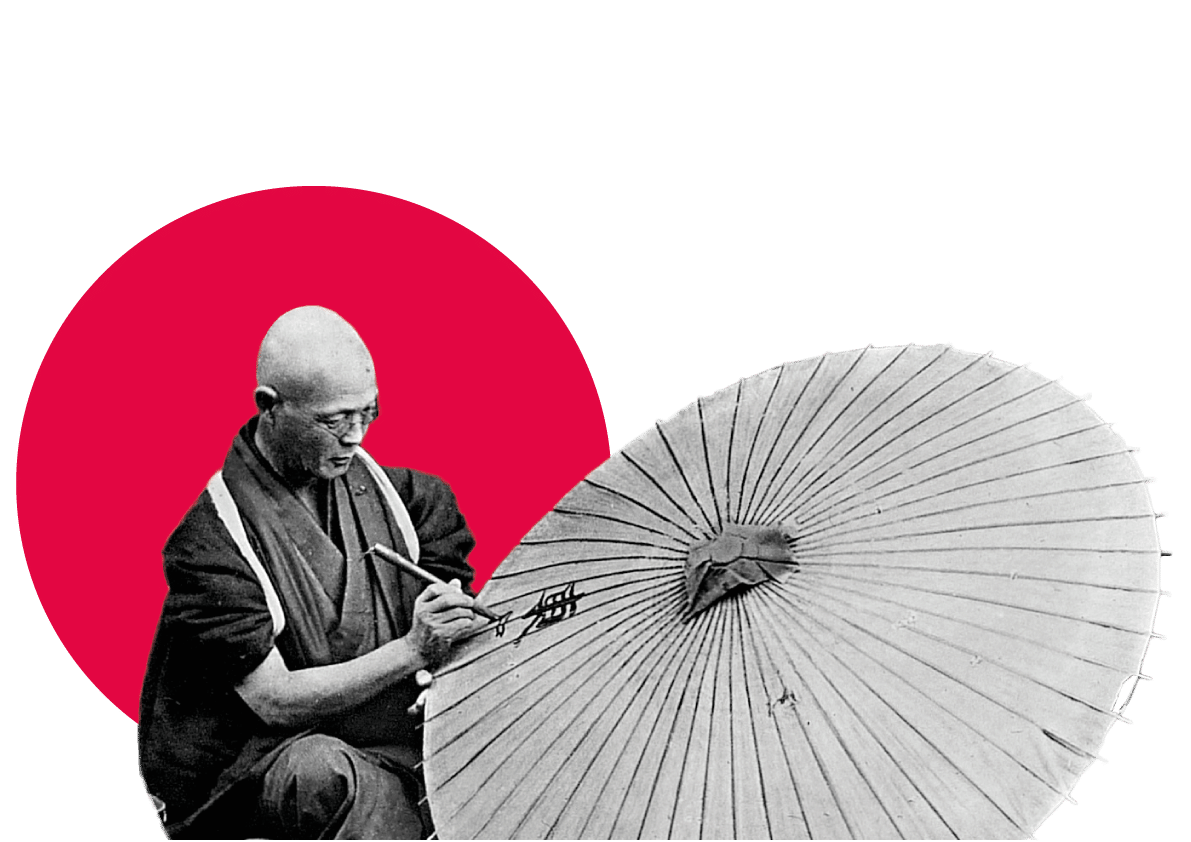 Artist painting Japanese umbrella against red circle backdrop.