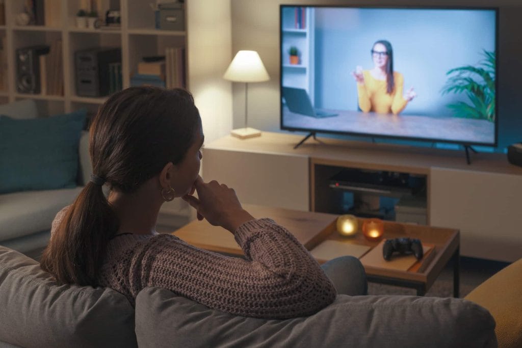 Femme regardant un cours en ligne sur son téléviseur