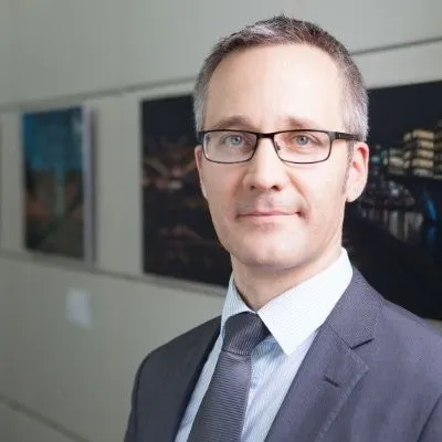 Professioneller Mann im Anzug mit Brille lächelt nach innen